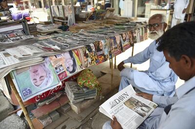 A man reads a copy of Pakistan's Dawn English-language newspaper in Karachi on May 20, 2018. Rizwan Tabassum / AFP Photo