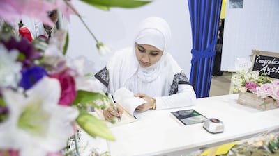 Aysha Al Naqbi signs copies of her novel Blue Moon at the Abu Dhabi International Book Fair Antonie Robertson / The National