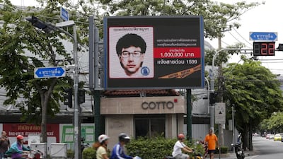 People ride their motorcycles past a digital billboard showing a sketch of the main suspect in the attack on Erawan shrine, in Bangkok on August 23, 2015. Chaiwat Subprasom/Reuters