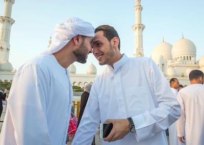 Worshippers greet each other after performing morning prayers at Sheikh Zayed Grand Mosque. Leslie Pableo for The National