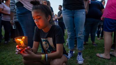 London Delgado kneels with a lighted candle at a vigil held in the wake of a deadly school shooting with multiple fatalities at Santa Fe High School, in Galveston, Texas. Stuart Villanueva / AP Photo