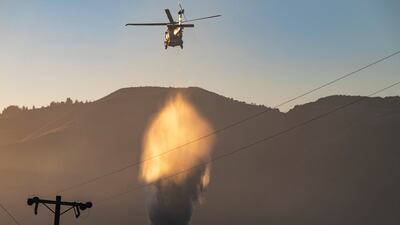 A helicopter drops water on the fire near Aromas, California. AP