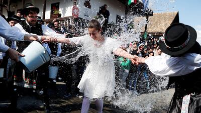 A woman in traditional dress has water thrown on her during a traditional Easter celebration in Holloko, Hungary. Reuters
