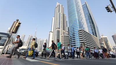 People cross the road at a busy intersection in Business Bay, Dubai. Chris Whiteoak / The National