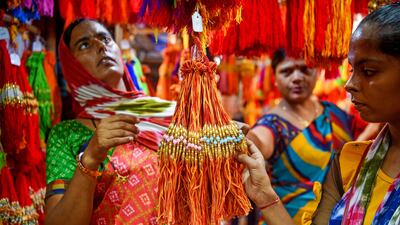 Women check out rakhis at a roadside stall in Mumbai. AFP