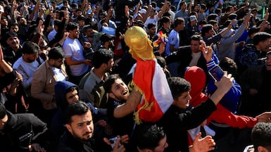 Iraqis celebrate in Baghdad on Wednesday after the national team beat Bolivia to qualify for the Fifa World Cup for the first time since 1986. Reuters