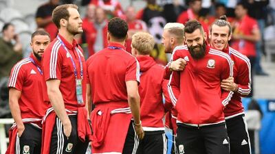 Wales forward Gareth Bale and Wales midfielder Joe Ledley walk on the pitch with teammates. Miguel Medina / AFP