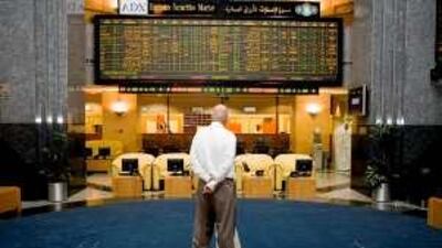 Empty leather chairs outnumber the traders at the Abu Dhabi Securities Exchange.