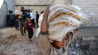 A boy carries bread in the northern Syrian town of Atareb, Aleppo province, in November 2012. One of Syria's militant groups, Jabhat Al Nusra, tries to employ soft power, and it implemented a bread distribution programme in Aleppo city that same year. Philippe Desmazes / AFP