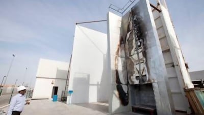 Manoj Kumar, manager of Al-Futtaim Exova, inspects a fire test on cladding surfaces.