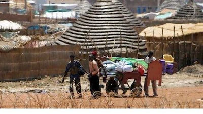 Armed men carry away property looted from a house in the town of Abyei, which was captured by troops from northern Sudan at the weekend. Stuart Price / UNMIS via AFP
