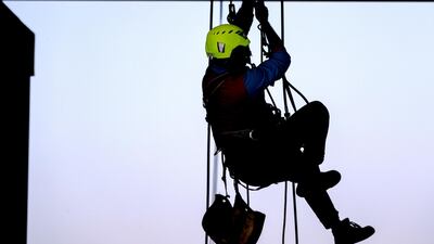 A cleaner is lifted up. Victor Besa / The National