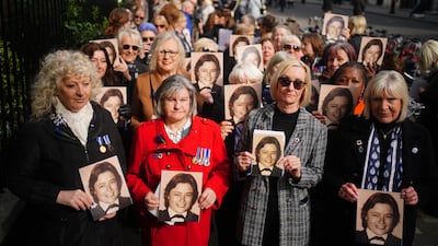 People hold photos of Pc Yvonne Fletcher as they gather for a 40th anniversary memorial service in St James's Square, London. Pc Fletcher was murdered on 17 April 1984 by a shot fired from the Libyan embassy in St James's Square, London, after she had been deployed to monitor a demonstration against the then Libyan leader Muammar Gaddafi. Picture date: Wednesday April 17, 2024. PA Photo. Her death resulted in an eleven-day siege of the embassy, at the end of which those inside were expelled from the country and the United Kingdom severed diplomatic relations with Libya. See PA story MEMORIAL Fletcher. Photo credit should read: Victoria Jones/PA Wire