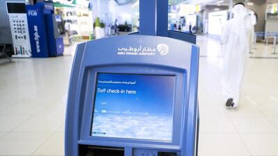 Above, a self check-in kiosk for the newly implemented smart travel system at Abu Dhabi International Airport. Christopher Pike / The National