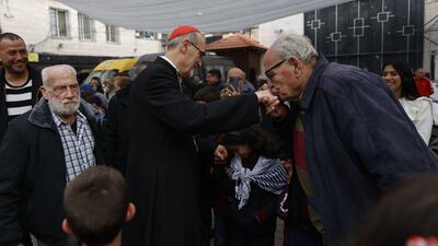 A man performs 'baciamano', kissing the Episcopal ring of Cardinal Pierbattista Pizzaballa, Latin Patriarch of Jerusalem, during a pastoral visit to the Holy Family parish in Gaza city. AFP