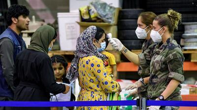A French soldier checks the temperature of a woman flown to the base from Afghanistan. AFP