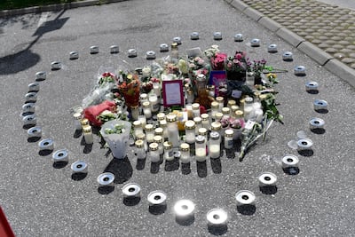 Flowers and candles in the shape of a heart where a twelve-year old girl was shot dead early August 2, 2020, at a motorway service area in Botkyrka, south of Stockholm, Sweden. EPA