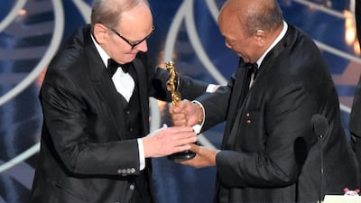 Ennio Morricone (L) accepts the award for Best Original Score for The Hateful Eight' from producer Quincy Jones at the Oscars on February 28, 2016 in Hollywood, California. AFP