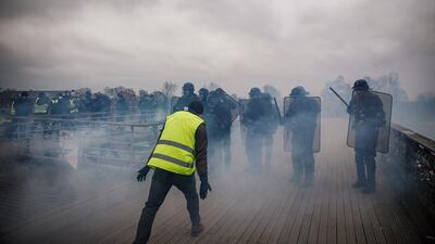 Demonstrators clash with riot police officers in Paris, during an anti-government demonstration called by the yellow vest "Gilets Jaunes" movement. AFP