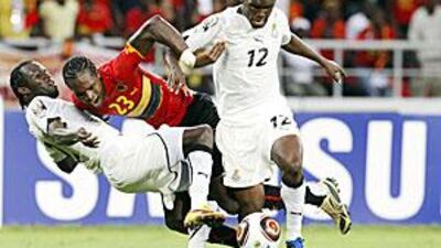 Angola's Manucho, centre, is sandwiched by two Ghana players on Sunday.