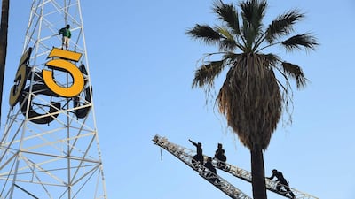 Police officers climb two fire ladders to reach a man standing on the KTLA radio tower in Hollywood, California.. Robyn Beck / AFP Photo