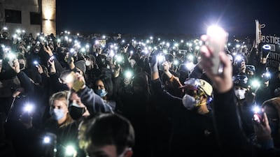 Demonstrators hold up their phones with the light shining near the Brooklyn Center police station during the sixth night of protests over the shooting death of Daunte Wright by a police officer in a Minneapolis suburb. AFP
