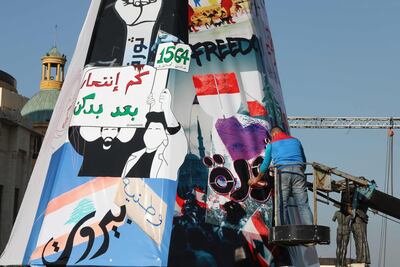 Lebanese anti-government protesters erect a Christmas tree made of protest banners in Beirut's Martyr Square. AFP