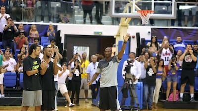 LA Lakers NBA player Kobe Bryant salutes the crowd as he arrives to American University of Dubai basketball court to coach a team made up of local celebrities on September, 27, 2013. AFP