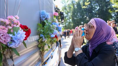 A women prays in Visoko, Bosnia, next to a lorry carrying coffins holding the remains of Srebrenica genocide victims. AP