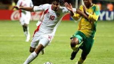 Theyab Awana, left, has South Africa's Andile Jali for company as he tries to make progress down the wing at Alexandria Stadium. Awana equalised for the UAE in the fourth minute of stoppage time to earn a 2-2 draw.