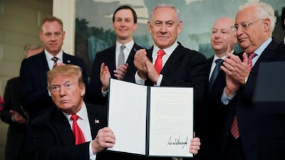 US President Donald Trump holds up his proclamation recognising Israel's sovereignty over the Golan Heights as Israeli Prime Minister Benjamin Netanyahu applauds. Reuters
