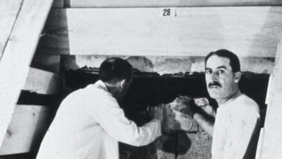 Howard Carter, right, opening the door to the tomb of Tutankhamun in 1922. Getty