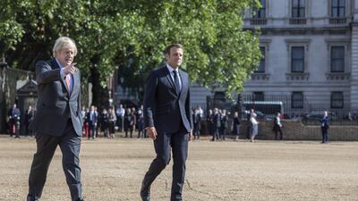 British Prime Minister Boris Johnson and French President Emmanuel Macron in Horseguards parade ground to watch the Red Arrows and La Patrouille de France fly over in London. Getty Images