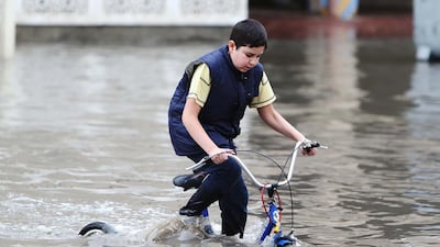 A boy rides a bicycle in a flooded street in the Qatari capital of Doha following heavy rainfall on November 25, 2015. Karim Jaafar/Al Watan Doha/AFP Photo