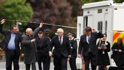 London mayor Boris Johnson (centre) walks under police tape near the scene of the killing of a British soldier in Woolwich.