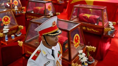 A soldier stands beside coffins containing the remains of fallen soldiers at Le Thi Rieng Park in Ho Chi Minh City, Vietnam. AFP
