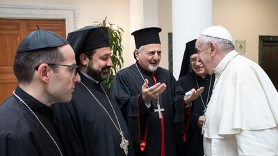 This handout picture taken and released by the Vatican Media on July 01, 2021 shows Pope Francis (R) smiling to Patriarch of Antioch and All the East for the Syriac Catholic Church, Ignatius Youssef III Younan (C), one of Lebanon's Christian leaders during a meeting at the Altar of Confession in Saint Peter Basilica in the Vatican on July 1, 2021. (Photo by - / VATICAN MEDIA / AFP) / RESTRICTED TO EDITORIAL USE - MANDATORY CREDIT "AFP PHOTO / VATICAN MEDIA" - NO MARKETING NO ADVERTISING CAMPAIGNS - DISTRIBUTED AS A SERVICE TO CLIENTS