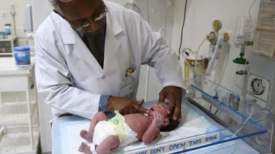 Dr Thomas Mathew checks a new born baby in the special care baby unit at the Oasis Hospital in Al Ain, which has since been renamed to the Kanad Hospital. Stephen Lock / The National.