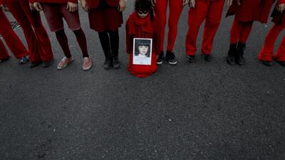A child holds a picture of a victim of gender violence in Buenos Aires, Argentina. Natacha Pisarenko / AP Photo
