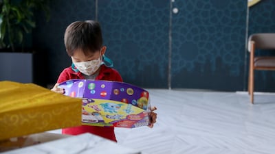 A young boy opens his gift at The Galleria Mall Al Maryah Island. Khushnum Bhandari / The National