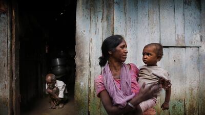 Chitramani Mahali, a tea worker, holds her son as her ailing father-in-law tries to walk out of their home in Bundapani. The workers’ situation highlights how eastern India’s tea industry has changed little since colonial times.
