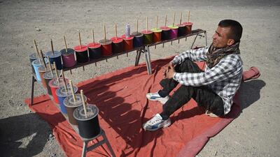 A string vendor waits for customers during a kite battle.