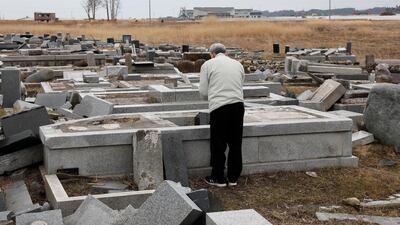 Hiroe Suzuki offers a prayer for his late father Hirotada, who was killed by tsunami at age of 91, at a cemetery in Ukedo district, Namie, Fukushima Prefecture, Japan, on March 11, 2018. Kimimasa Mayama / EPA