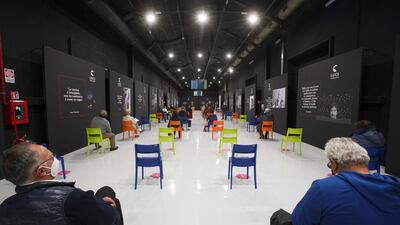 People sit in a waiting room after receiving a dose of the Pfizer vaccine, at a vaccination center set up at Rome's Cinecitta' film studios in Italy. AP Photo
