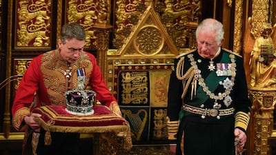 Britain's Prince Charles, Prince of Wales (R) looks on as the The Imperial State Crown (L) is placed beside him in the House of Lords Chamber during the State Opening of Parliament at the Houses of Parliament, in London, on May 10, 2022. - Queen Elizabeth II missed Tuesday's ceremonial opening of Britain's parliament, as Prime Minister Boris Johnson tries to reinvigorate his faltering government by unveiling its plans for the coming year. (Photo by Alastair Grant / POOL / AFP)