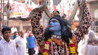 An Indian devotee dressed as Hindu deity Shiva holds a snake as he participates in a religious procession on the occasion of the Ram Navmi festival in Amritsar. Narinder Nanu / AFP