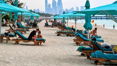 Beach-goers lie on lounge chairs by the shoreline at the Jumeirah Al Naseem, Dubai. Private beaches reopened with social distancing measures in place before public beaches. AFP