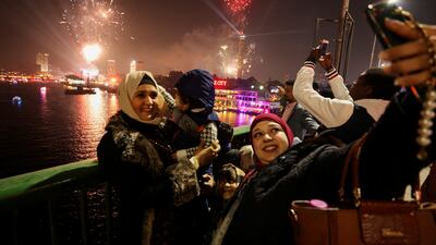 People take pictures as fireworks explode over the Nile River during the New Year celebrations, in Cairo. Reuters