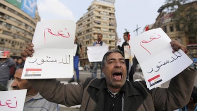 A man holds signs in support of Egypt's draft constitution during a demonstration at Tahrir Square in Cairo on Friday. Mohamed Abd El Ghany / Reuters