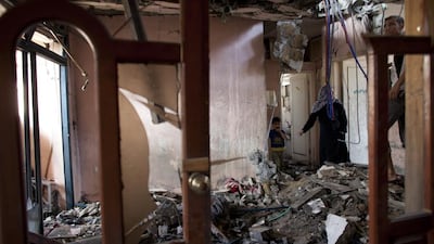 The Aziz family examines their destroyed home in the Sheikh Zayed City neighbourhood of Gaza. Heidi Levine for The National